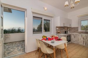 a kitchen and dining room with a table and chairs at Ammoudi Harmony Villa in Amoudi
