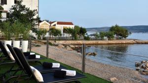 - une vue sur une étendue d'eau avec deux chaises longues dans l'établissement Beach apartment Paklenica-Deluxe, à Seline