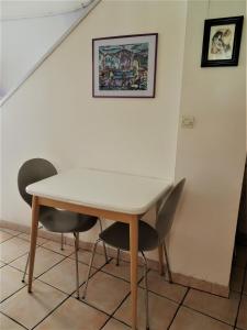 a table and chairs in a room with a staircase at Maison De Village in Saint-Raphaël +6 photos