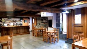 un restaurant avec des tables et des chaises en bois ainsi qu'un bar dans l'établissement Hostal Lopenea, à Leitza