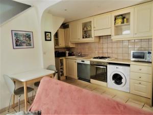 a kitchen with a stove and a washer and dryer at Maison De Village in Saint-Raphaël