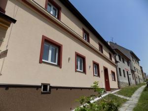 un edificio con ventanas rojas en el lateral. en Ubytování Apartmány Ferenčíková, en Nové Hrady