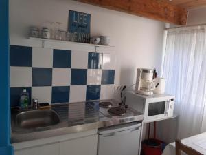 a small kitchen with a sink and a microwave at Les Lamparos in Palavas-les-Flots