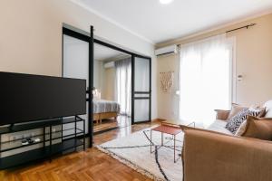 een woonkamer met een tv en een bank bij NEW LUXURY CENTRAL BOUTIQUE in Thessaloniki