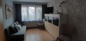 ein Wohnzimmer mit einem TV, einem Sofa und einem TV-Stand in der Unterkunft Ferienhaus Waterstrat in Stolberg i. Harz