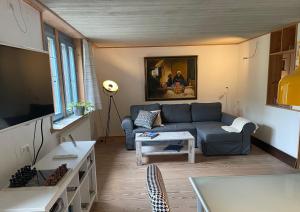 a living room with a couch and a table at Rose Cottage im romantischen Taubertal in Adelshofen