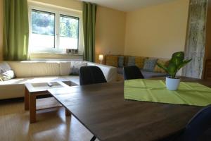 sala de estar con mesa y sofá en Haus Daheim, en St. Wolfgang