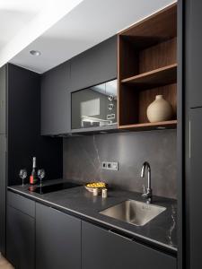 uma cozinha com armários pretos e um lavatório em Casa das Trabancas em Tui