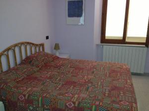 a bedroom with a bed with a red and green quilt at Casa Lucia in Rosignano Solvay