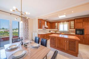 a kitchen with a dining table and a large window at Kanali Hill House in (( Agía Eleoúsa ))