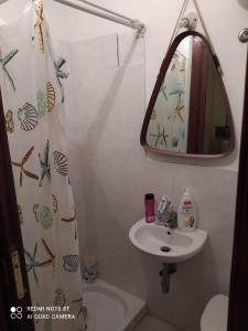uma casa de banho com um lavatório e um espelho em per noi 2 em Capo dʼOrlando