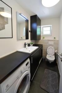 a bathroom with a sink and a washing machine at Stone Diamond in Zadar