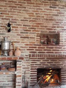 a brick fireplace with a fire in it at Guest house Gidi in Sighnaghi