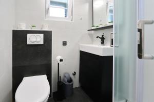 a bathroom with a white toilet and a sink at Stone Diamond in Zadar +34 photos