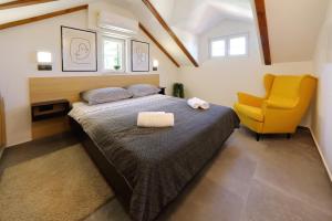 a bedroom with a bed and a yellow chair at Stone Diamond in Zadar