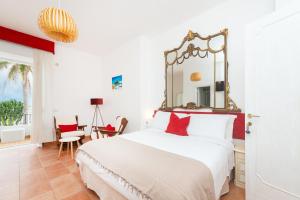 una camera da letto con un letto e uno specchio a parete di Villa Bina Sea Hotel a Ischia