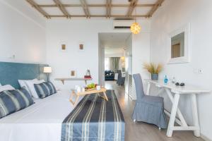 a bedroom with a bed and a table and chairs at Rigas Boutique Hotel & Spa in Afitos