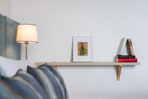 a shelf with a picture and a lamp on a bed at Rigas Boutique Hotel & Spa in Afitos