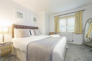 Un dormitorio blanco con una cama grande y una ventana en 7 Camelside en Wadebridge