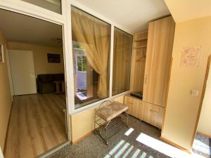 een kamer met een raam en een stoel. bij Neringarent DRUSKĖ - 2-jų miegamųjų su atskiru įėjimu in Juodkrantė