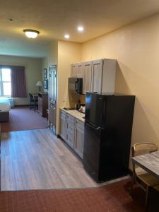 a kitchen with a black refrigerator in a room at AmericInn by Wyndham Fargo Medical Center in Fargo