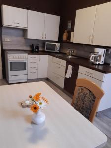 eine Küche mit einem Tisch und einer Blumenvase darauf in der Unterkunft Ferienwohnung Weiß in Aue