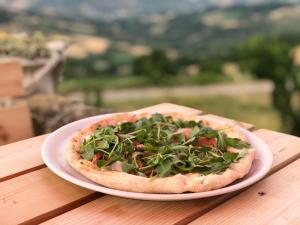 pizzę siedzącą na talerzu na stole w obiekcie Mini Casale Rustico ColleBello w mieście Castiglione Messer Raimondo