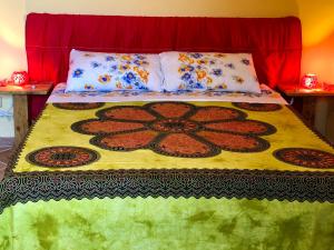 un letto con coperta colorata e cuscini sopra di Mini Casale Rustico ColleBello a Castiglione Messer Raimondo