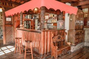 a bar with two stools and a red umbrella at Chalé Terrazza in Campos do Jordão