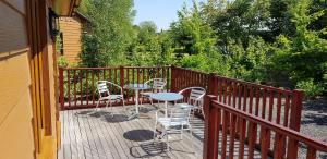 a wooden deck with tables and chairs on it at Walnut Lodge, Summerhayes in Bridgwater