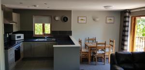 a kitchen with a table and a dining room at Walnut Lodge, Summerhayes in Bridgwater
