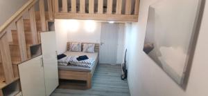 um pequeno quarto com uma cama e uma escada em New cosy studio em Karlovy Vary