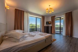 a bedroom with a large bed with a large window at SILVER MOUNTAIN - ANA'S Apartments in Poiana Brasov