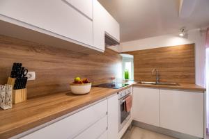 a kitchen with white cabinets and a bowl of fruit on the counter at Antique center Pula in Pula +17 photos