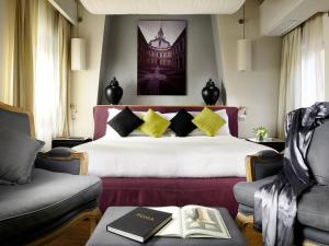 um quarto de hotel com uma cama e duas cadeiras em Mario De' Fiori 37 em Roma