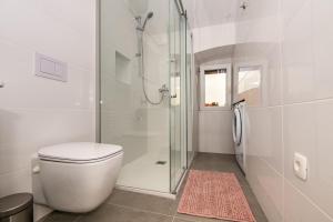 a white bathroom with a toilet and a shower at Antique center Pula in Pula