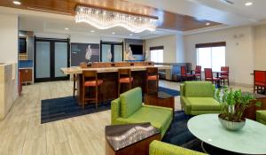 um átrio com um bar, cadeiras e uma mesa em Holiday Inn Express-International Drive, an IHG Hotel em Orlando