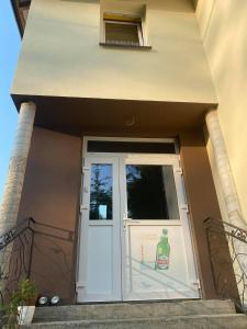 a white door with a bottle on the side of a building at Apartamenty Otrytturystyka in Ustrzyki Dolne