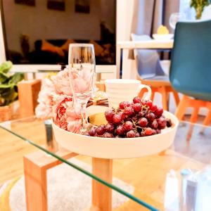 a bowl of grapes and a wine glass on a table at Modern 4 bedroom flat near Brighton Station in Brighton & Hove