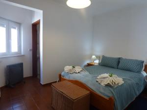 a bedroom with a bed with two pillows on it at Apartamento Rosa in Vila Nova de Milfontes