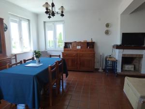 a dining room with a blue table and a television at Apartamento Rosa in Vila Nova de Milfontes