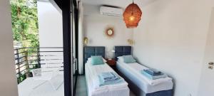 two beds in a room with a balcony at BOHO MARE Apartament Pobierowo in Pobierowo +36 photos
