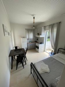 a bedroom with a bed and a table and a kitchen at Asteria House in Animborió