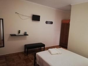 a room with two beds and a television on the wall at Anestis Studios in Agios Georgios
