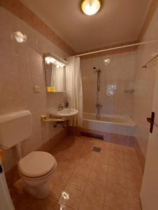 La salle de bains est pourvue de toilettes, d'un lavabo et d'une baignoire. dans l'établissement Kuća Luce, à Mali Lošinj