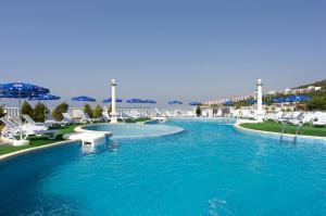 a swimming pool with chairs and blue water at Hotel Amore Beach - All Inclusive Light in Elenite