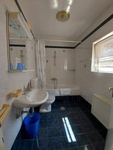 a bathroom with a sink and a tub and a toilet at Kuća Luce in Mali Lošinj