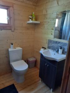 a wooden bathroom with a toilet and a sink at Cyprus Glamping Park in Ayios Theodhoros