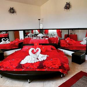 una camera con due letti con lenzuola rosse e rose di Indipendente con PISCINA USO ESCLUSIVO Internet illimitato a Siniscola