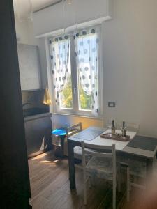 tavolo e sedie in cucina con finestra di TERRAZZA SUL MARE IN VIA DEVOTO a Chiavari